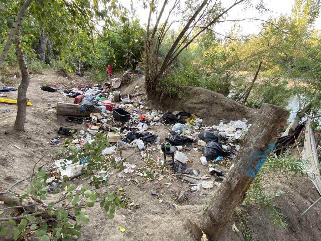 Bags of trash, empty propane canisters, and more trash litter the Clark Fork Riverfront in Missoula